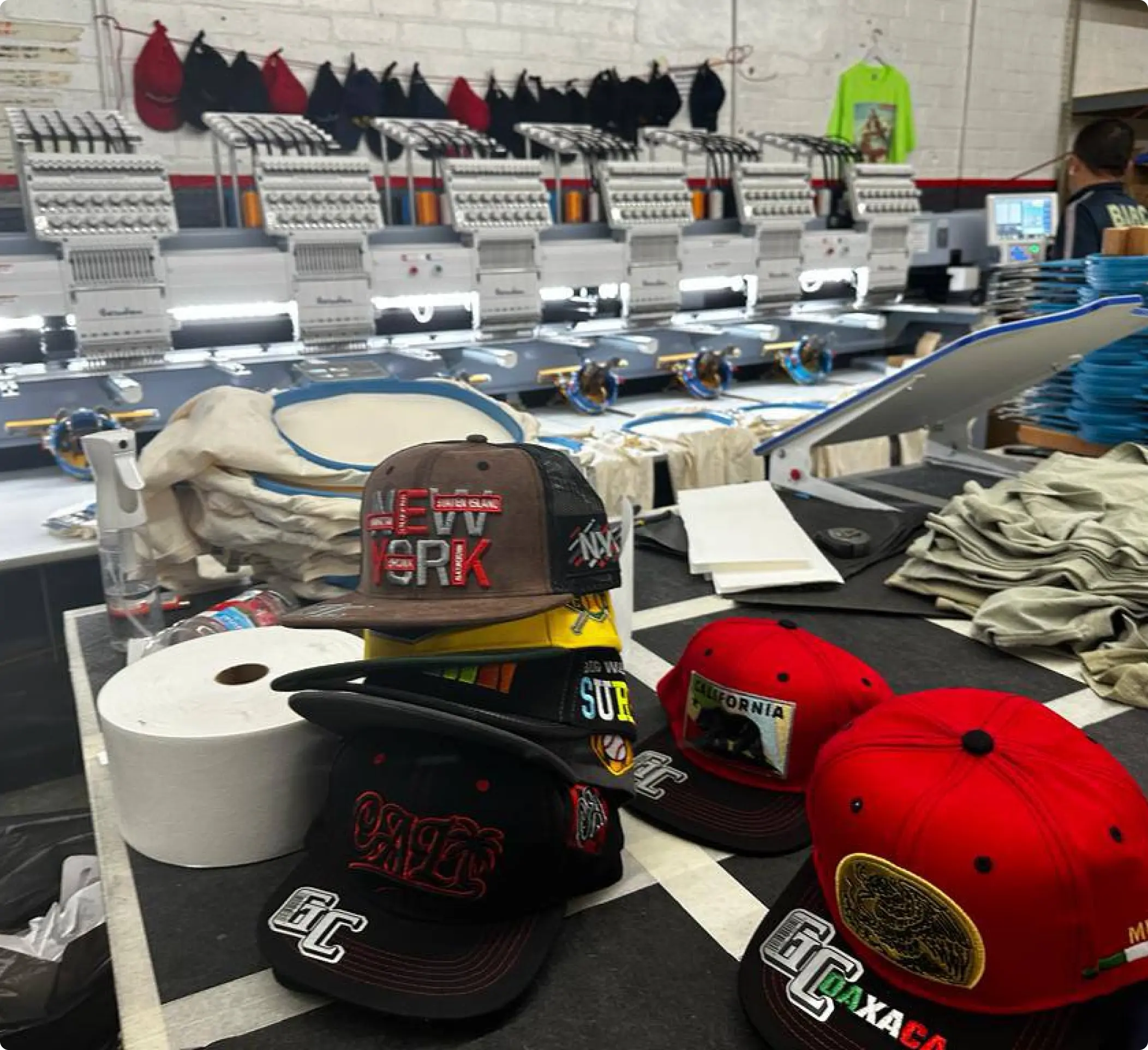 Embroidered hats in front of printing machine