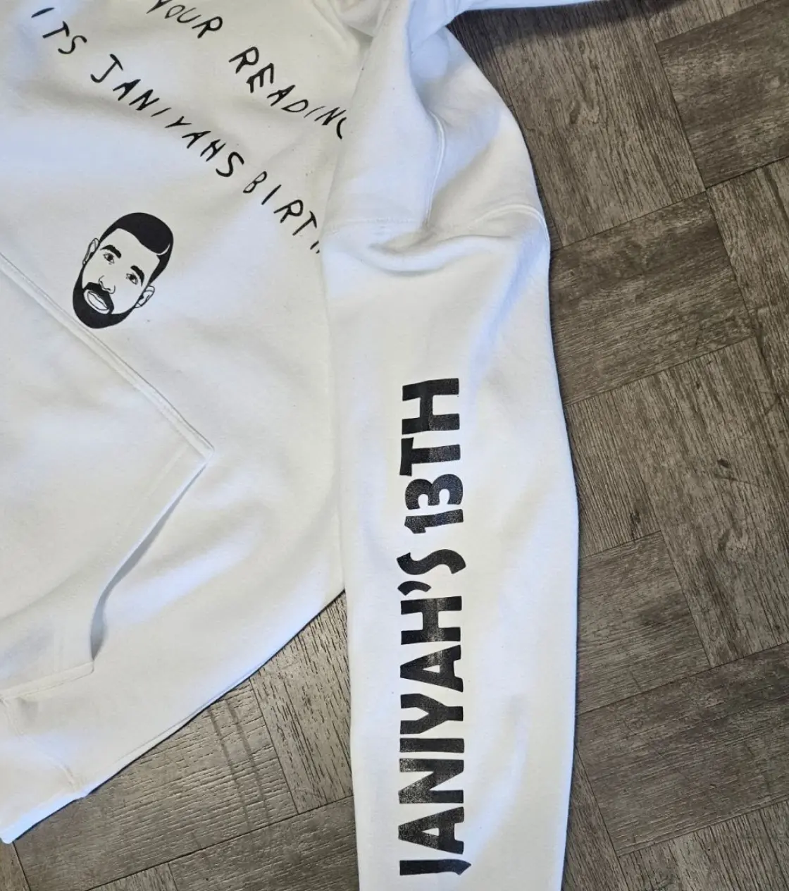 White hoodie with text on the sleeves of it